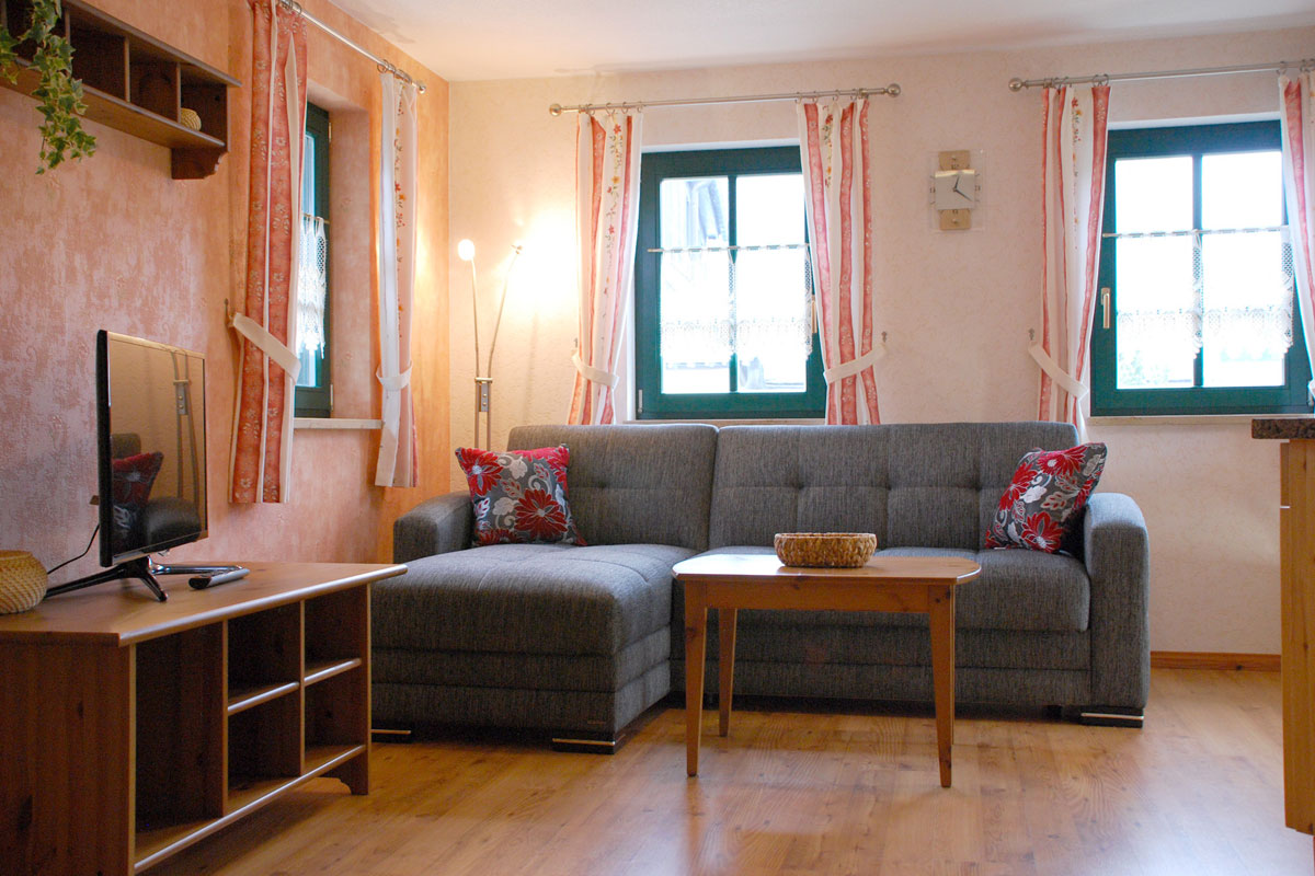 Talsuite - Wohnzimmer mit TV und Sofa