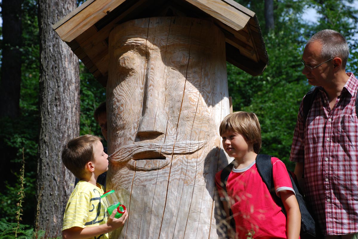Waldhusche - Familie mit Holzskulptur